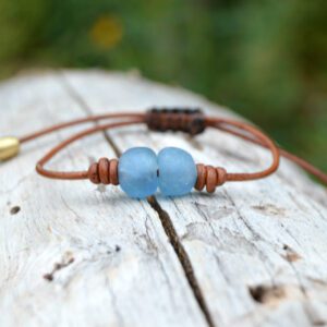 Adjustable leather bracelet with macrame knot and two sky blue African recycled glass beads.