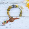 Bracelet with rustic African and ethnic beads in natural colors and pendant with whale tail and shark teeth.