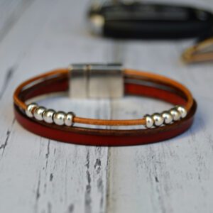 Bracelet en cuir rouge et perles de zamak argentées avec fermoir magnétique.