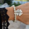 Silver bead and leather bracelet with button clasp and four-leaf clover charm.