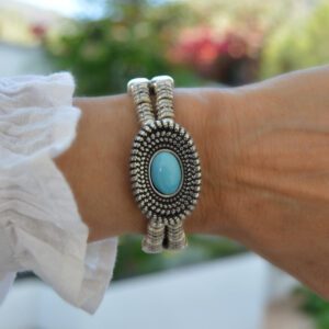 Silver plated zamak bangle bracelet with oval turquoise blue murano glass bead and button clasp.