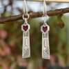 Long earrings in silver with rectangle pendants in ethnic style and red hearts charm. Hippy hooks