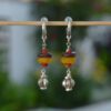 Boucles d’oreilles argentées avec perles de verre africain recyclé et détails en zamak